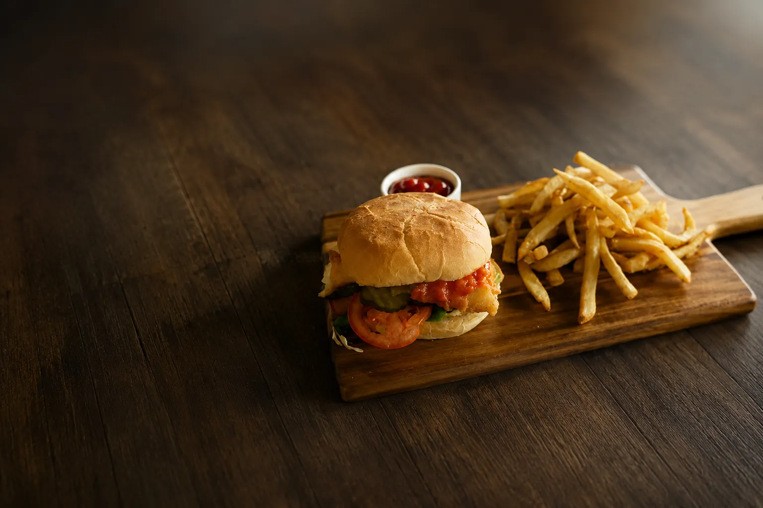 Crispy fish burger at Jackson Heights Fish And Chips Winnipeg - battered fish fillet in a soft bun with lettuce, tomato and fries